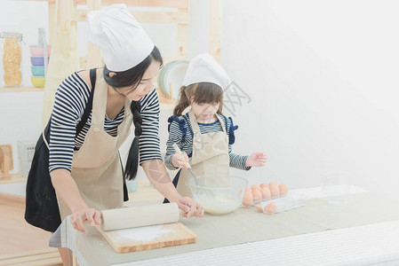 厨房里的幸福家庭亚洲母亲和她的女儿准备面团做蛋糕家庭孩子和快乐的人概图片