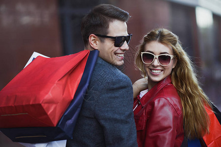 图片显示年轻夫妇在城市购物一对夫妇在城市购物袋的画像人销售爱图片