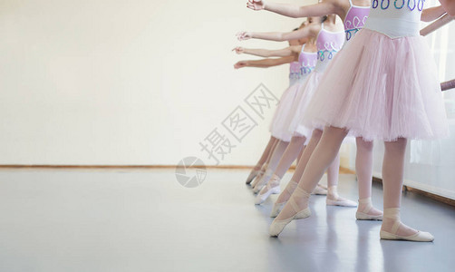 在芭蕾舞课上伸展脚尖的小芭蕾舞图片