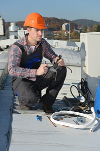 空调修理机修屋顶空调系统的年轻维修员背景图片