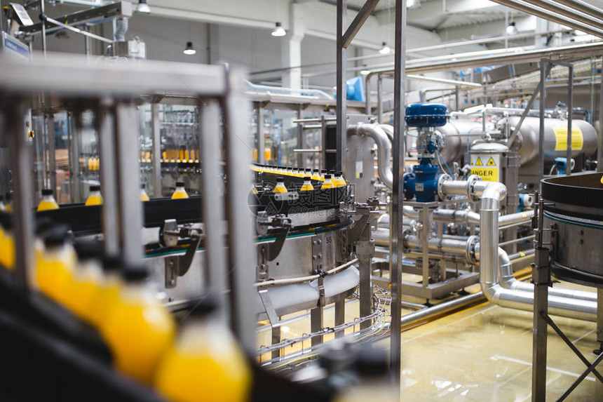 室内工业厂和机械用于加工和装瓶苏打水和橙汁瓶的机器人生产线选择图片