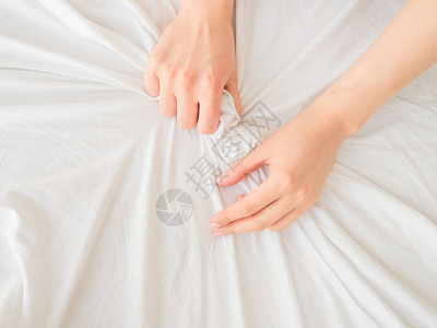 女手放在白色的床单上图片