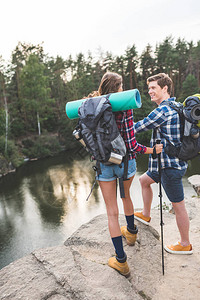 生活跃的年轻夫妇背包有徒步旅行和站图片