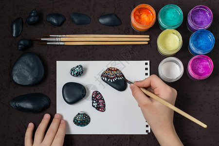 在海卵石和贝壳上手绘彩色圆点图案背景图片