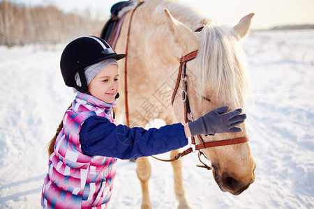 穿着骑马头盔的小女孩背景图片