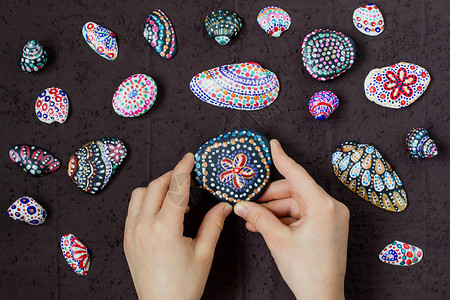 在海卵石和贝壳上手绘彩色圆点图案背景图片