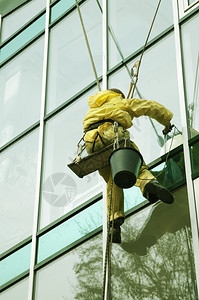 爬上摩天大楼门面的窗户清洁工图片