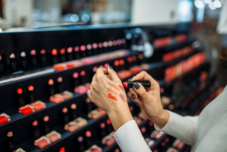 女顾客在化妆店测试口红颜色特写图片