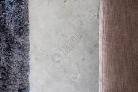 从上面的水泥地板上的深灰色软地毯和米色沙发最小的室内设计细节冷图片