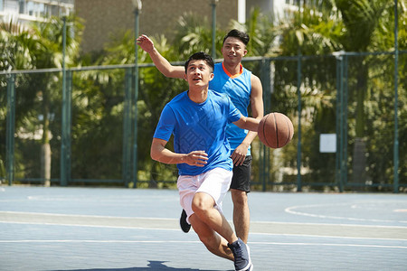 年轻的年青男篮球运动员在户外法庭上图片