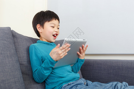 亚洲小男孩在平板电脑上玩游戏图片