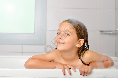 在浴缸里玩水和泡沫的女孩图片