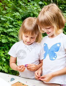 两个小女孩在户外玩泥土图片