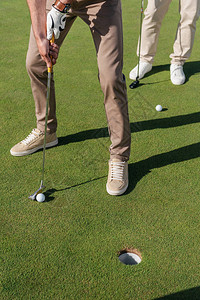 职业高尔夫球手准备击球的短镜头背景图片