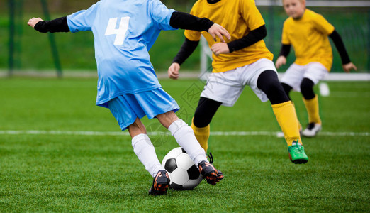 儿童足球比赛孩子们玩足球比赛男孩在草地上图片