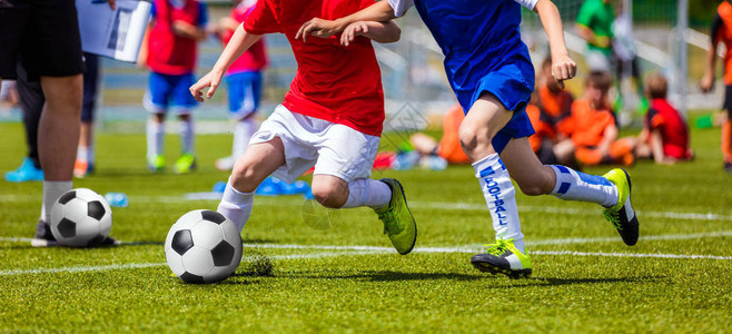 儿童足球比赛孩子们玩足球比赛男孩跑和踢足球中的图片