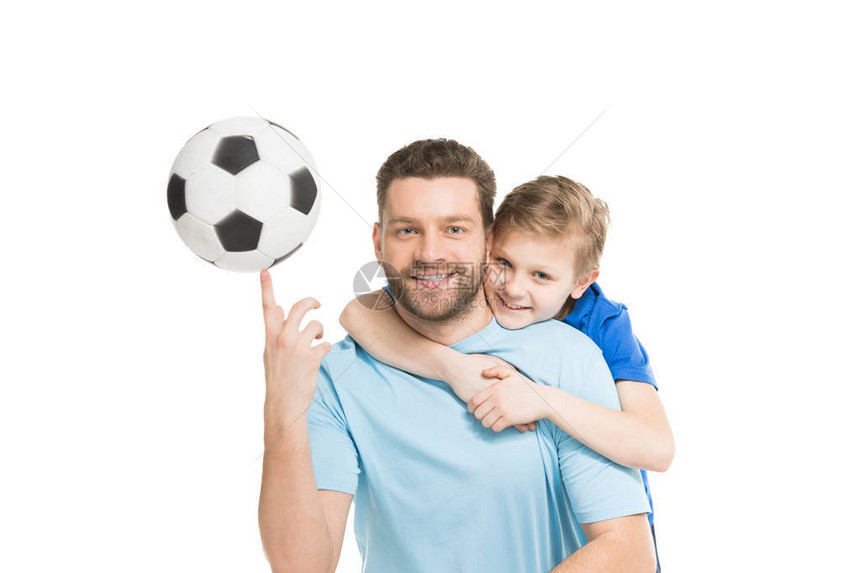 年幼的父亲和儿子冒着足球在图片