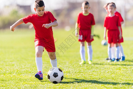 儿童足球幼儿球员在足球场上比赛图片