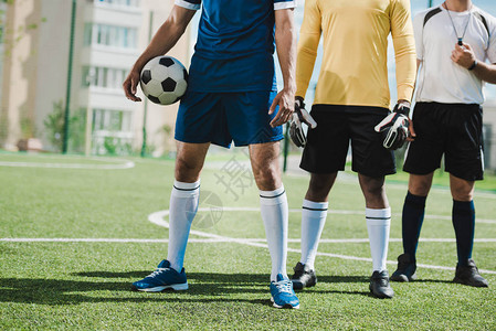 足球运动员和裁判在比赛前站在足球场图片