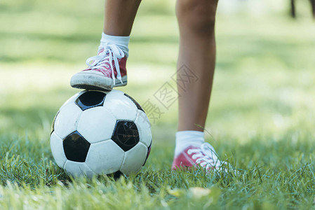 儿童在草地上与足球站图片