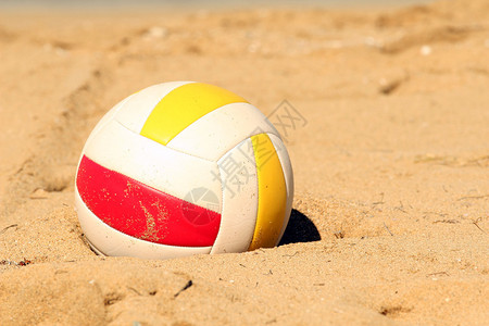排球躺在沙滩上的沙子里图片