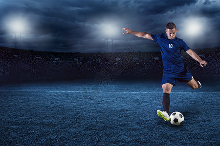 专业足球或足球员夜间在全环状球体育场比赛时拍摄行动背景图片
