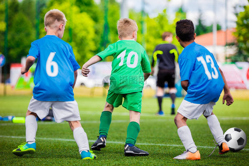 足球运动员在球场上带着球奔跑足球运动员在球场上踢足球比赛年轻的青少年足球比赛图片