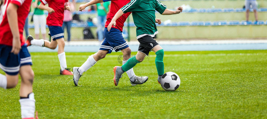 在体育场的足球运动员行动青少年足球比赛年轻男孩在绿色足球场上图片