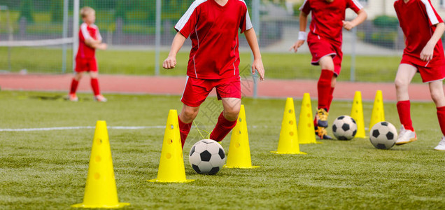 孩子们的足球训练营男孩们在田野里练习运球员发展良好的足球运技巧孩子们用球和锥体训练足球激流回旋训练以提高背景图片