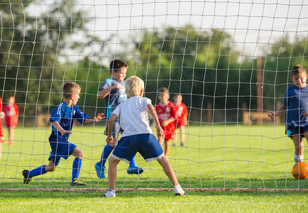 年轻男孩踢足球比赛图片