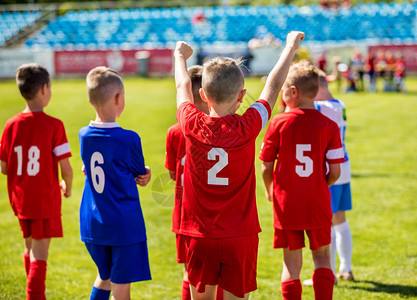 快乐的男孩赢得足球比赛年轻成功的足球运动员在球场上优胜者图片
