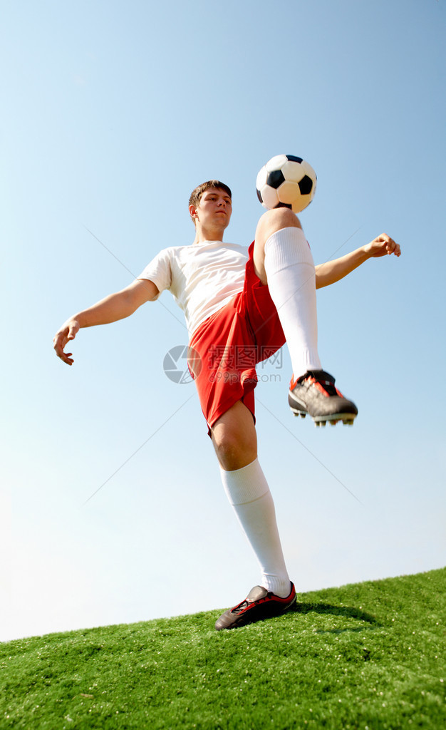 足球运动员在足球场上跪图片