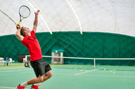 由职业网球运动员发球网球馆室内网球发男子拿着网球拍图片