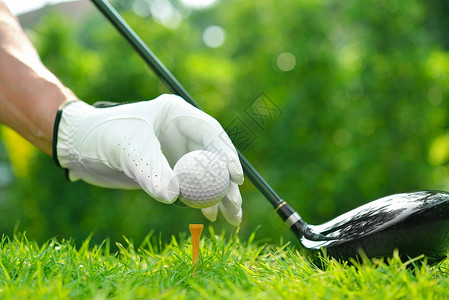 高尔夫球手的拿着高尔夫球与高尔夫球场背景的图片