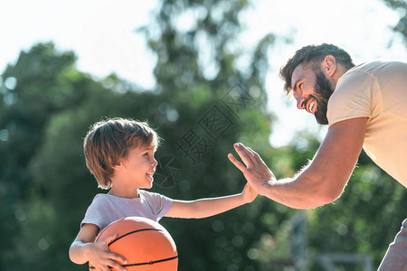 快乐的男孩和爸在篮球场图片