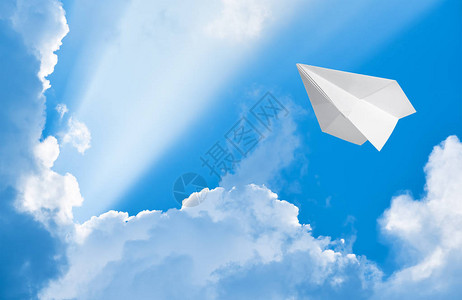 纸飞机在云间的天空中飞翔图片