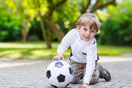 活跃可爱的小男孩踢足球和足球图片