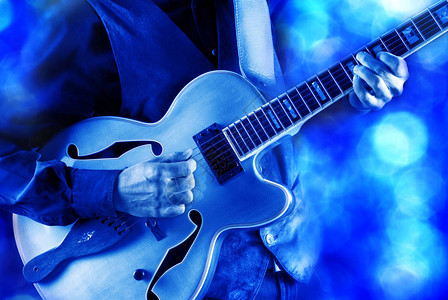 爵士吉他手弹吉他在蓝光下图片