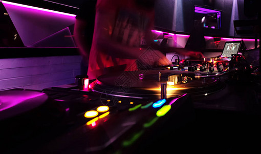 迪斯科DJ专业的唱片骑师或节目主持人在唱片转盘和混音器上播放曲目图片