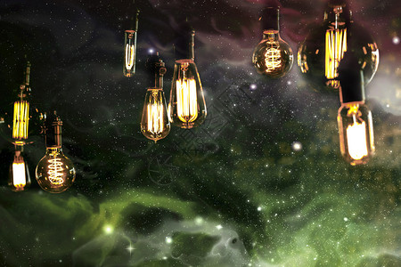 爱迪生风格的光灯泡以对抗星系和星背景图片