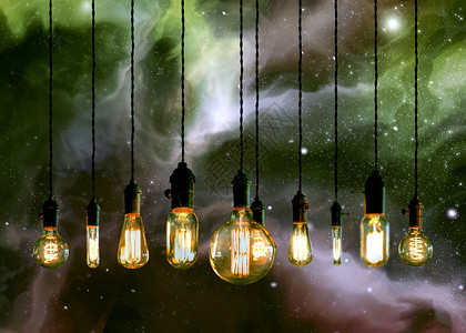 爱迪生风格的光灯泡以对抗星系和星背景图片