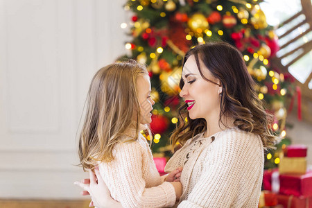 圣诞树旁的妈和可爱的女儿图片