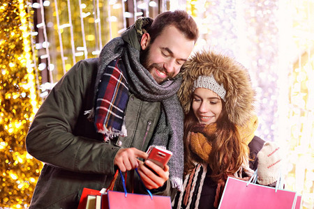 显示圣诞节期间在城里购物的成人情侣照片图片