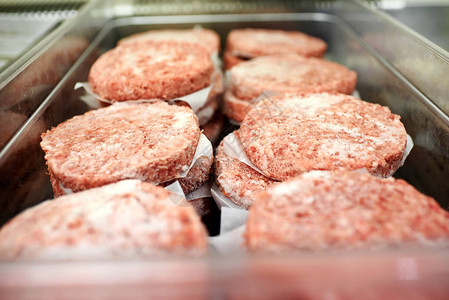 在餐馆或屠宰场用防油纸隔开的冷冻地牛肉汉堡图片