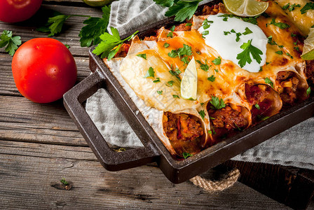 墨西哥菜南美食传统的辣牛肉玉米卷饼配玉米豆类番茄在烤盘上图片