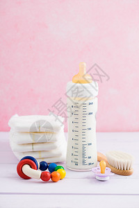 婴儿瓶奶嘴机理发刷尿布和粉背景图片