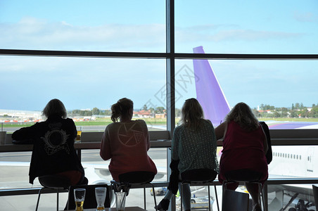 有飞机背景的乘客在机场航站图片