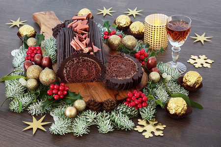 巧克力圣诞蛋糕与雪利酒冬季植物箔巧克力和质朴橡木背景上的装饰品节图片