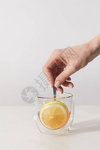 人手和玻璃杯用新鲜草药茶勺子图片
