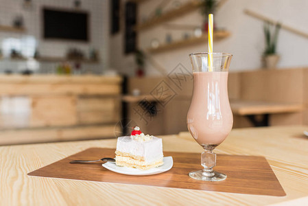 咖啡馆里的美味蛋糕和一杯奶昔图片